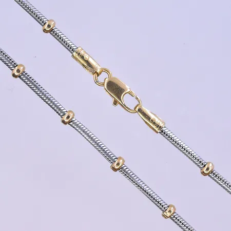 Collier längd 46 cm, bredd 2-3 mm vitguld/gulguld 18K. Vikt: 13,7 g