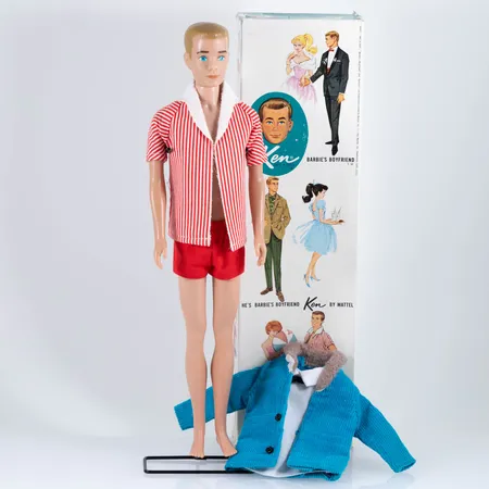 Ken docka "He's a doll" Barbie's boyfriend by Mattel Inc. Hawthorne Calif. USA 1960 Stock no. 750 med kläder, ställ och originalförpackning. Manchesterjacka och kortärmad vit skjorta medföljer.