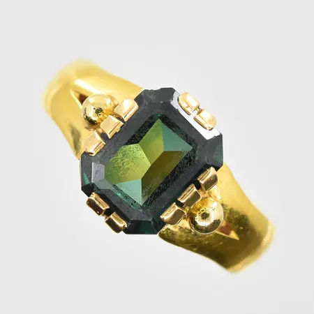 Ring med grön sten stl:18½, bredd 5-11mm, gravyr, skena 23K samt fattning 18K. Vikt: 6,9 g