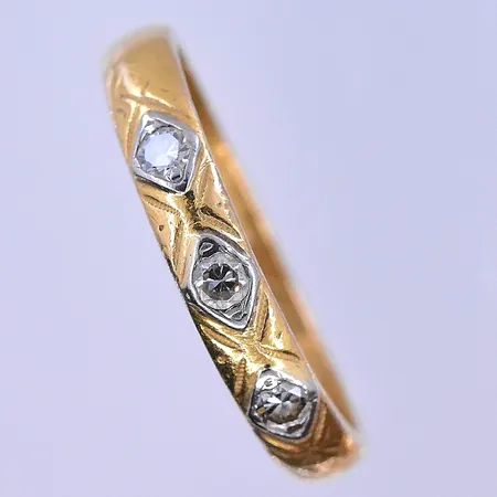 Ring med vita stenar stl:19, bredd 4 mm vitgulds detaljer graverad 23K. Vikt: 5,3 g