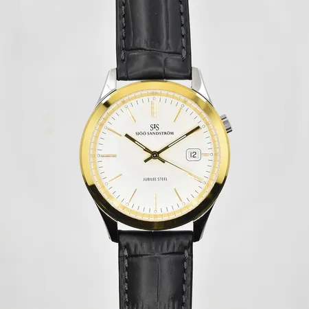 Herrur Sjöö Sandström Jubilee Steel, quartz, Ø40mm, refnr SS-1340-1, serienr 4600, kaliber SS G10, förgylld vridring, läderband, nyskick, företag/namngravyr på bakboett, garantibevis 2026-01-06, etui samt ytterkerong.