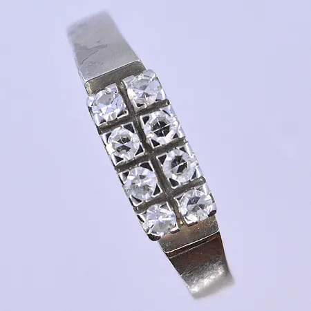 Ring med vita stenar stl:18½, bredd 2-5 mm vitguld 18K. Vikt: 3,4 g