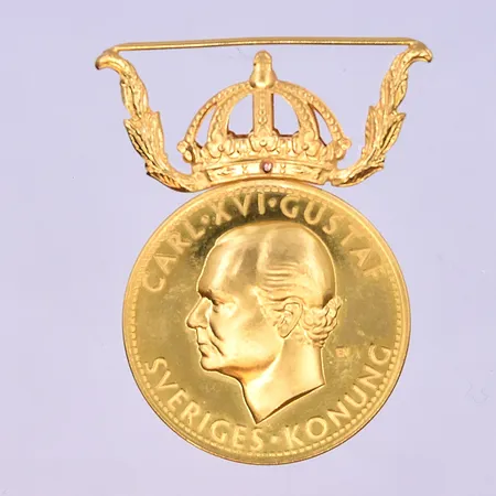 Medalj Gustaf VI Adolf längd 40 mm, bredd 32 mm 23K. Vikt: 14,2 g