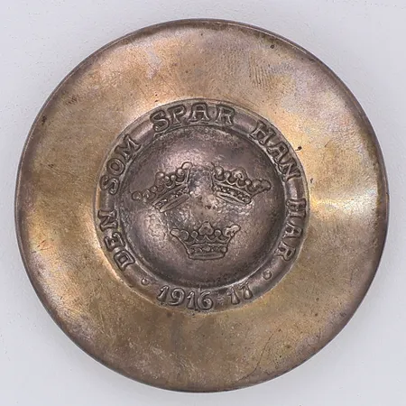Puderdosa Ø69mm "Den som spar han har" 1916-17, kattfot, silver 830/1000 Vikt: 42,1 g