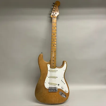 Elgitarr Stratocaster, hopplock, Fenderlogga ditsatt på huvudet, möjligen ej original, naturbeige, bakplatta, knapphuvud och serienummer saknas, mjukt fodral, defekter, inget ljud vid testtillfället, defekt elektronik Skickas med postpaket.