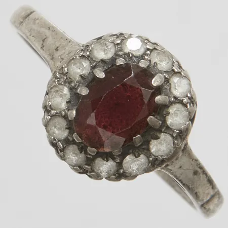 Ring med en granat ca.6,5x5mm samt vita stenar, stl:19, bredd: 2-11,1mm, engelska stämplar, silver 925/1000 Vikt: 2,3 g
