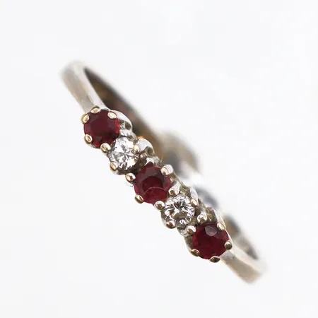 Ring med rubiner och diamanter 0,40 enligt gravyr, stl:18½, bredd ca 1,6mm, vitguld 18K. Vikt: 2,4 g