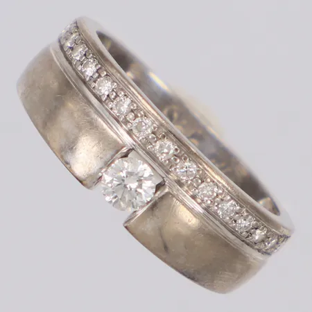 Ring med briljantslipad diamanter 1x0,16ct, 15x0,01ct, stl:17, GHA, gravyr, repor, vitguld 18K  Vikt: 6,1 g