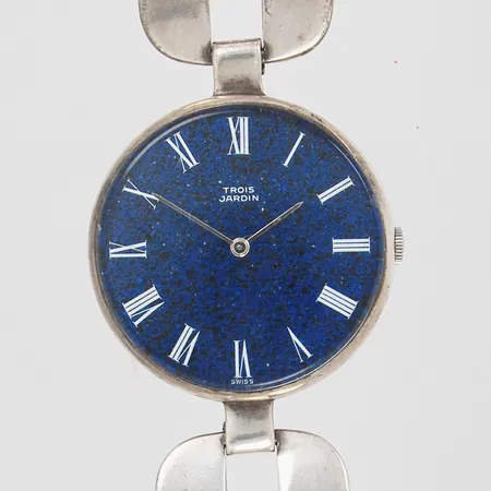 Damur Trois Jardin med emaljerad urtavla, manuell, Ø 35mm, längd på armband 17,5cm, bredd på armband 24mm, boett samt armband stämplade Ulysse Nardin, armband samt boett i silver 925/1000. Bruttovikt: 55,6 gram.