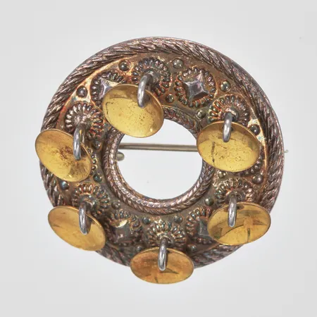 Brosch med dekor i relief och guldpläterade berlocker, Ø27mm, silver 925/1000. Vikt: 3,8 g