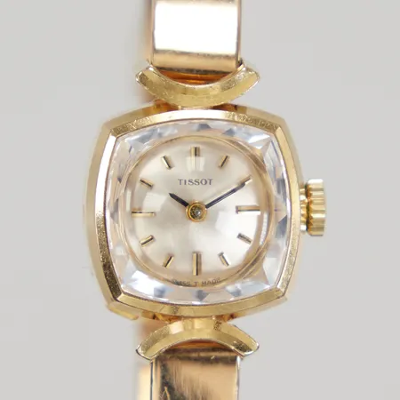 Damut Tissot ca 16X16mm, manuell, fasettslipat glas, stelt armband, mått ca 16cm inklusive uret, gravyrer, 18K. Bruttovikt: 27,9g Vikt: 0 g