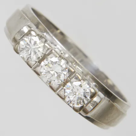 Ring med 3 diamanter 0,60ctv enligt gravyr, ca.TCr-W (I-H) / SI, rondistskada, stl:19+, bredd: 4-5,3mm, svenska stämplar, repig, behov av rodiering, vitguld, 18K Vikt: 7,1 g