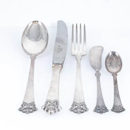 Norska silverbestick modell Anitra 57 delar i silver 830/1000. 12 skedar 185 mm, 12 gafflar 185 mm, 12 knivar med rostfria blad 215 mm, 2  smörknivar, 12 kaffeskedar 115 mm, 5 uppläggningsskedar 140 - 235 mm, 1 uppläggningsgaffel 100 mm, 1 såsslev 165 mm.  Totalt 2100g (varav 878g delarna med rostfria blad). Bruksskick. Skickas med postpaket.