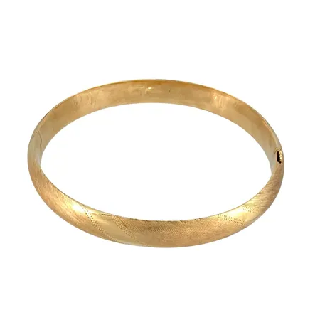 Armring i 14K guld, borstad och mönstrad modell, oval form, öppningsbar, inre omkrets 17,0 cm, bredd 8 mm, fint skick, den platta låsstaven inuti armringen någon ojämn Vikt: 11,4 g