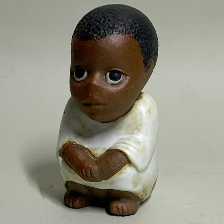 Figurin "Syd" Lisa Larson för Rörstrand ur serien All Världens Barn, höjd 10,5cm, etikettmärkt, stämplar, delvis glaserat stengods