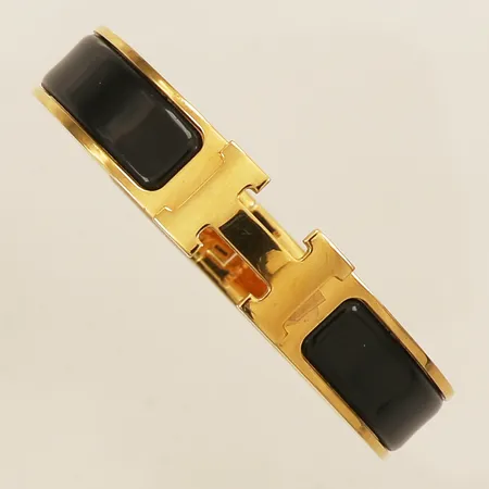 Armband Hermés Clic Clac gulmetall med svart emalj ST 0119 Made in France Ø55x45mm innermått 15,5cm, bredd 11,5mm dustbag skyddsplast kvar sliten kartong, instruktionsbok, kvitto från Brown Thomas Dublin 2020