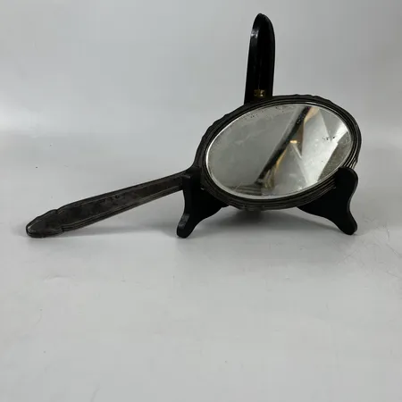 Hanspegel i silver, längd 31,5cm, bredd 11cm, monogram/gravyr, repigt, bucklor, viss defekt i spegel, bruttovikt 333,4g, 925/1000 silver.