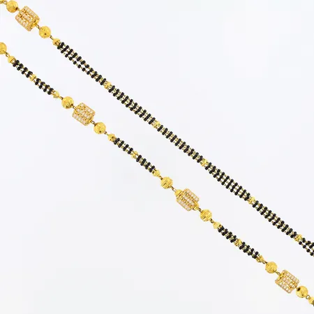 Collier med svarta och vita stenar, längd: ca 64cm, bredd: ca 4-9mm, defekt vita stenar saknas, bruttovikt: 43,5 gram, 22K Vikt: 43,5 g