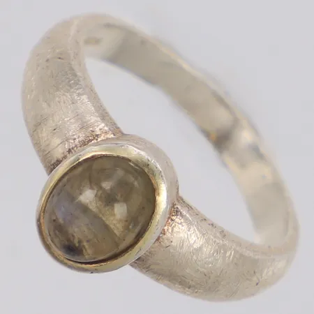 Ring med cabochonlipad rökgrå sten med inslag av blått sken, möjligen labradorit, borstad yta på skena, stl:18¾, bredd 10mm, 925/1000 silver Vikt: 5 g
