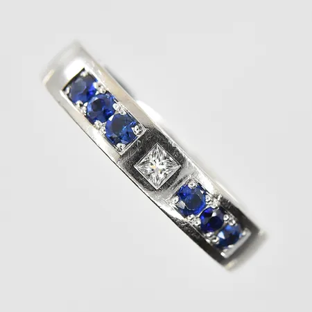 Ring med princesslipad diamant ca 0,05ct samt safirer stl:18¼, bredd 4mm, vitguld, 18K. Vikt: 9,8 g