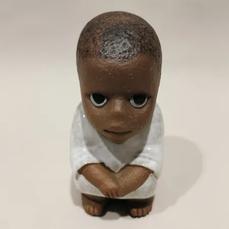 Figurin Syd ur serien All världens barn formgivare Lisa Larson Gustavsberg höjd 10,5cm stengods etikett samt stämpelmärkt krackeleringar