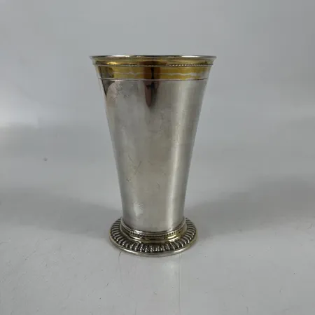 Bägare, förgyllda detaljer och insida, höjd 12cm, bredd 41,7-74,2mm, 830/1000 silver. Vikt: 90,1 g