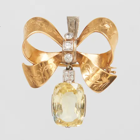Hänge/Brosch med gul safir & diamanter, 3 x ca 0,05ct, 4 x ca 0,01ct, längd inkl ögla ca 36,5mm, bredd ca 31mm, rosett, omarbetat hänge GD & Co ca 1936 & Carl Larsson 1949, 18K Vikt: 11,0g Vikt: 11 g