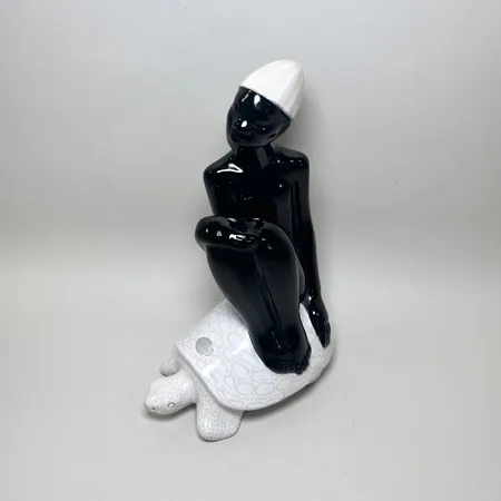 Figurin Mari Simmulsson för Upsala Ekeby, kvinna sittande på en sköldpadda, höjd ca 27cm, etikettmärkt.