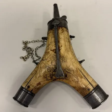 Kruthorn, troligen Tyskland tidigt 1600-tal, längd 23cm, bredd 15cm, horn med graverad dekor, beslag i metall, sprickor