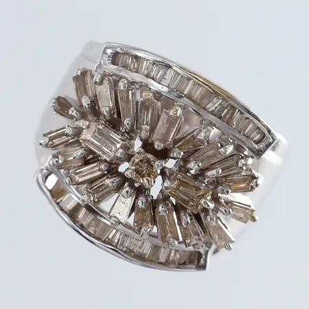Ring med diamanter ca 1 x 0,05ct baguette/trapetsslipning 33 x 0,01ct 22 x 0,04ct, totalt ca 1,25ctv, naggade stenar, stl:18 bredd 6-16,5mm otydliga stämplar vitguld 18K. Vikt: 9,2 g