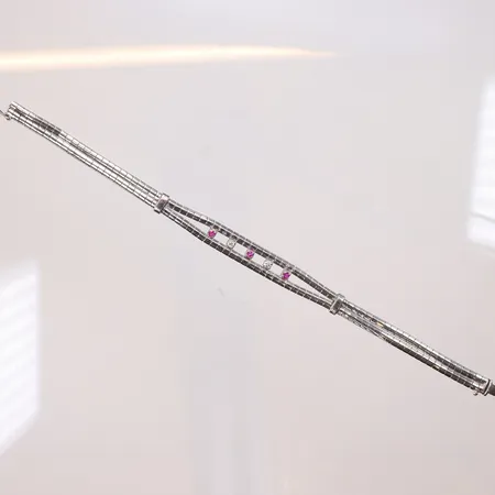 Armband i vitguld med röda stenar samt diamanter 2xca0,05ct 19cm bredd 6-9mm svensk importstämpel 18K Vikt: 19,9 g
