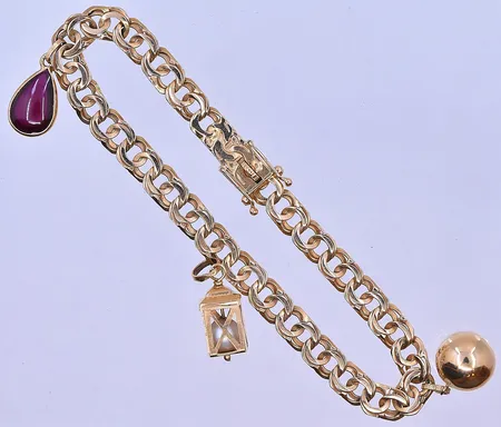 Armband Bismarck med 3 berlocker längd 18,5cm bredd 6mm klämskada på 1 berlock 18K. Vikt: 12,4 g