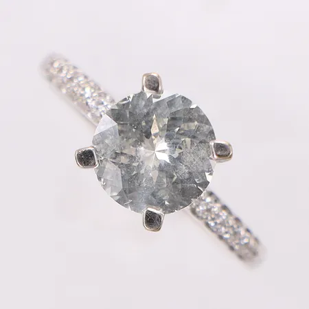 Ring med sten samt diamanter 12 x ca 0,01ct stl:18, bredd 2,1-8mm, mindre nagg på rondist på vita stenen, 18K Vikt: 4,4 g