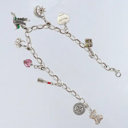 Armband med nio berlocker längd 21cm bredd 5mm Silver 925/1000. Vikt: 21,9 g på auktion i Kista hos Pantbanken Sverige
