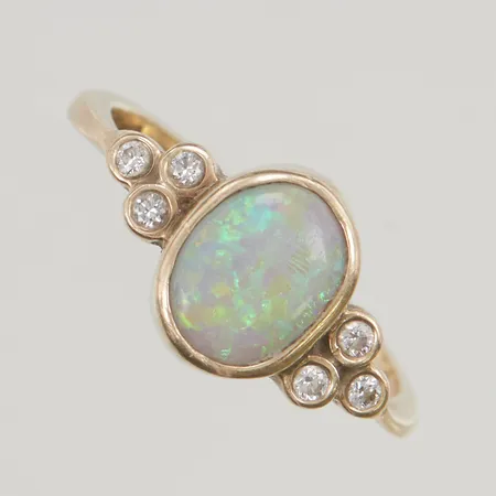 Ring med diamanter 6x ca 0,025ct samt opal, stl:18¼ bredd 11mm stämplad 9K?, håller för 14K 3,3g.