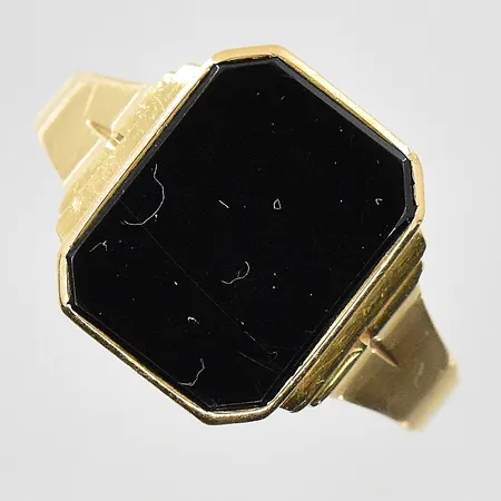 Klackring med onyxplatta stl:20, bredd 3-14 mm, gravyr, repig sten, 18K. Vikt: 4,2 g
