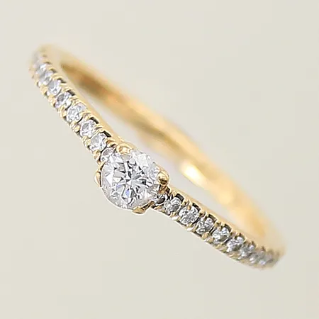 Ring med diamanter 1 x ca 0,15ct 24 x ca 0,005ct GHA stl:16 bredd 1,6-3,4mm en sliten klo 18K Vikt: 2 g