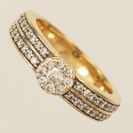 Ring med diamanter ca 36xca0,01ct, 8xca0,02ct 1xca0,10ct, stl:16¾ bredd 5,7mm GHA 18K  Vikt: 7 g