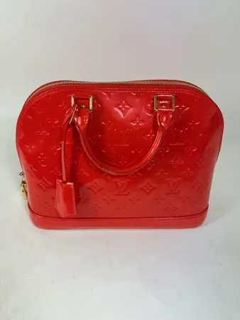 Väska Louis Vuitton Alma BB monogram klarrött vernisläder, detaljer i gulmetall, lås samt nycklar medföljer, bredd 32 cm, höjd 24 cm, djup 15 cm, made in France, inga övriga tillbehör.
