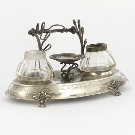 Bläckställ i silver med glasbehållare, cirka 17,5x8,5cm, höjd cirka 8cm, 1800-talets andra hälft, O.Sandberg, gravyr, smärre bucklor/skevheter, ena glasbehållaren saknar silverring, handtagets ena fäste löst, silver 830/1000, silvervikt 153,1gram Vikt: 153,1 g Skickas med postpaket.