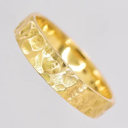 Ring hamrad yta stl:23¾ bredd 5,6mm graverad 18K Vikt: 9,5 g på auktion i Västerås hos Pantbanken Sverige