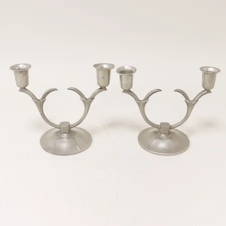Ett par ljusstakar Fabriksaktiebolaget Kronsilver svenskt tenn, höjd 14cm bredd 17cm, tilltryckningar och repor. Skickas med paket.