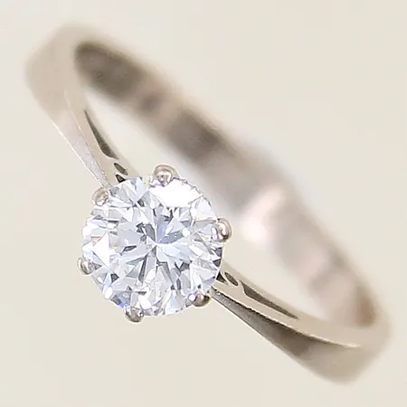 Ring med diamant 0,77ct enligt gravyr kvalitet ca W(H)/SI fjäder som når ytan stl:17¾ bredd 2,6-5,9mm vitguld behov av omrodiering 18K Vikt: 3,3 g