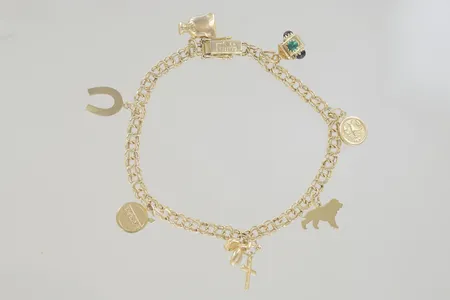 Armband bismark med berlocker, längd 19cm, bredd 5 mm, 18K Vikt: 12,8 g på auktion i Växjö hos Pantbanken Sverige