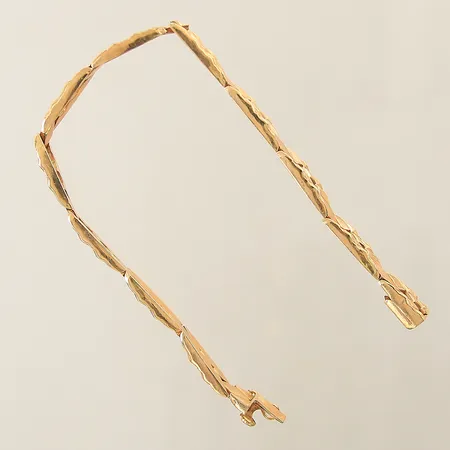 Armband halvstelt med genombruten dekor längd 19cm bredd 6,8mm en skev länkbit 18K Vikt: 12,3 g på auktion i Solna hos Pantbanken Sverige