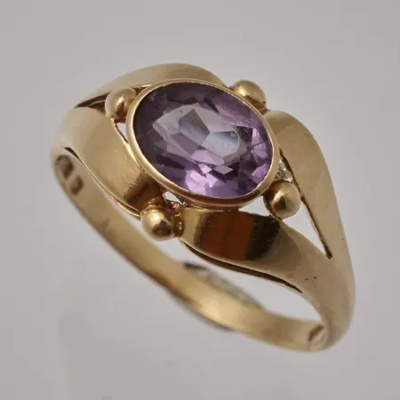 Ring i 18K guld, stl18, bredd 1,8-10,7mm, 1st lila sten, mått 6x8mm, otydlig ansvarstämpel, kattfot, bruttovikt 3,59g, ca nettovikt 3,2g.