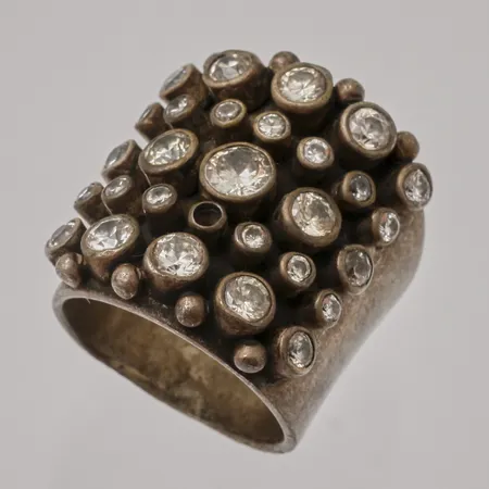 Ring stl:18½ Kumkum bredd 14,4-25,7mm, 28st vita stenar, 1st saknas, skev skena, repor, 925/1000 silver, 23,17g.