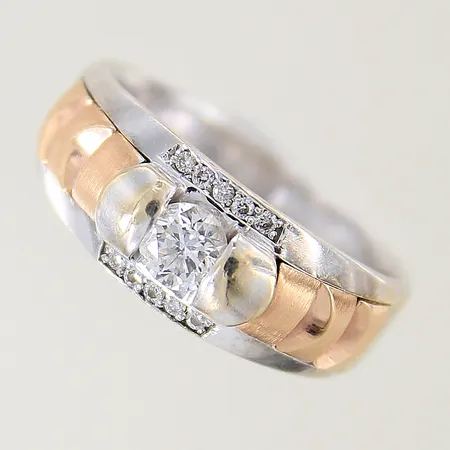Ring med diamanter 1 x ca 0,38ct kvalitet ca Cr(J)/P samt 10 x ca 0,01ct stl:18¼ bredd 3,6-8,5mm tvåfärgad behov av omrodiering 18K Vikt: 9,3 g