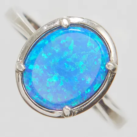 Ring syntetisk opal stl:18¾ bredd: 3-4,2mm, silver 925/1000 Vikt: 4,3 g på auktion i City hos Pantbanken Sverige