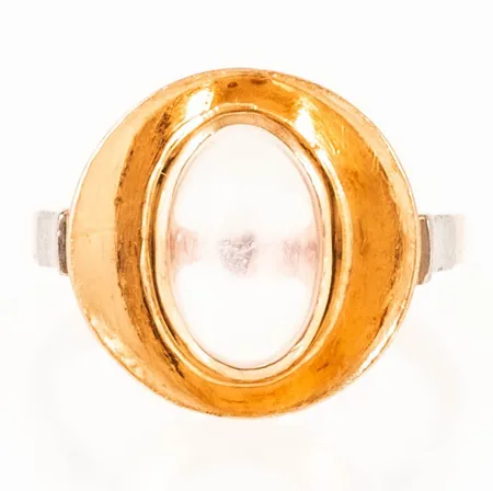 Umeåtillverkad ring med en cabochonslipad sten (troligen månsten) stl:17½ bredd 2,1-15,3mm, stämplad D9 (1954), FK (Kjellins AB, Umeå), kattfot, repig sten, men fin lyster ändå, 18K 5,8g.
